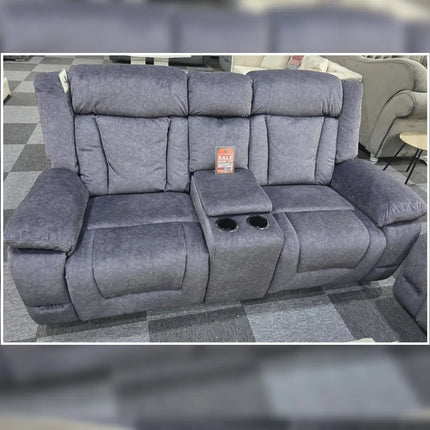 Gray recliner sofa with cup holders and a small table on a checkered floor.